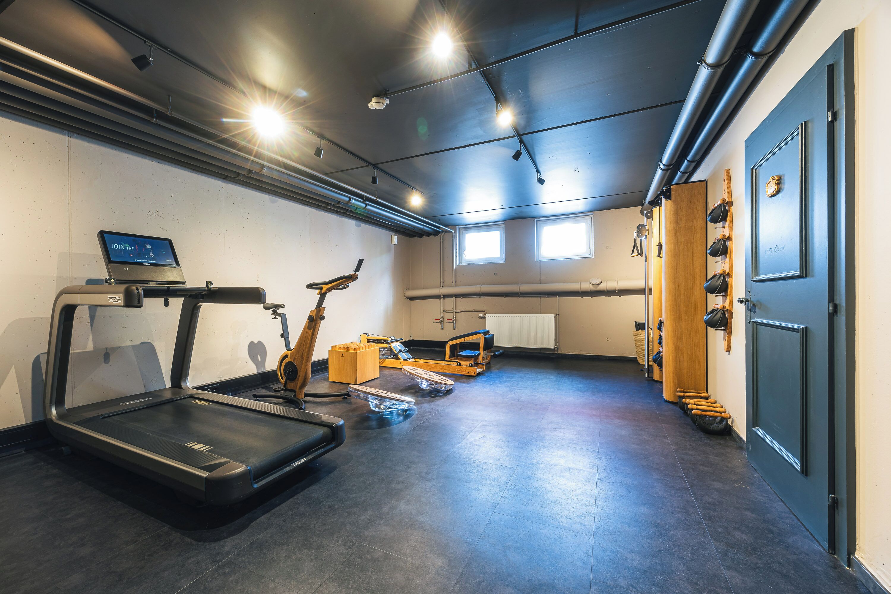 A gym with treadmills, exercise bikes, and a rowing machine.
