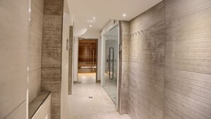 Un pasillo moderno con una puerta de cristal que da a una habitación de madera.