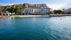 Un hotel frente al mar con vistas al océano y montañas al fondo.