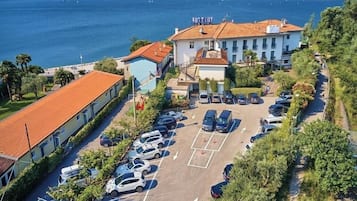 Un hotel sul lungomare con parcheggio, piscina e vista mare.