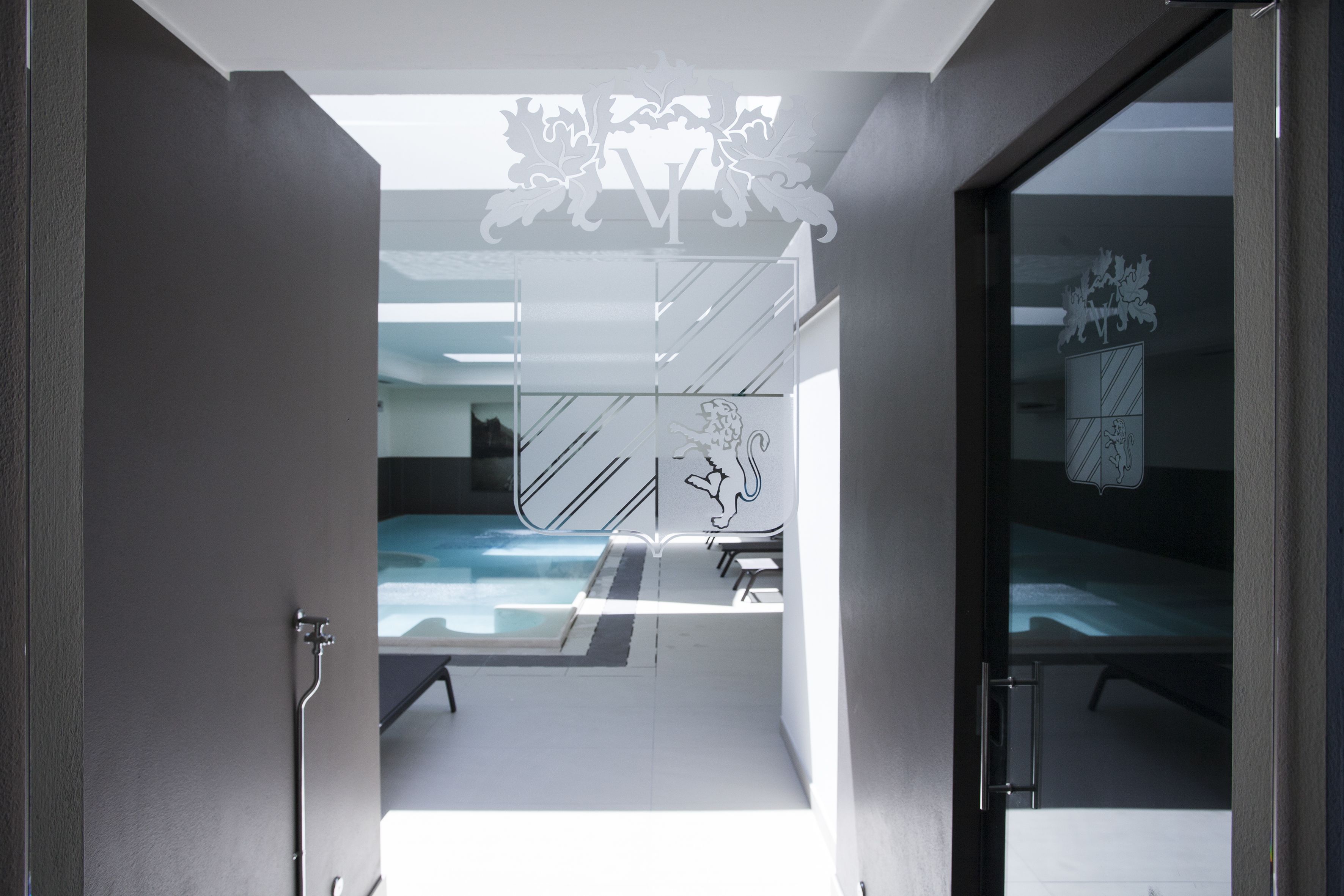 A modern hotel room with a glass door leading to a pool area.