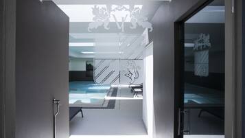 A modern hotel room with a glass door leading to a pool area.