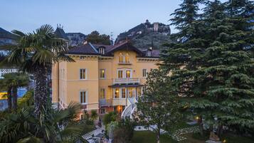 A large, yellow building with a balcony and a staircase leading to a second floor.