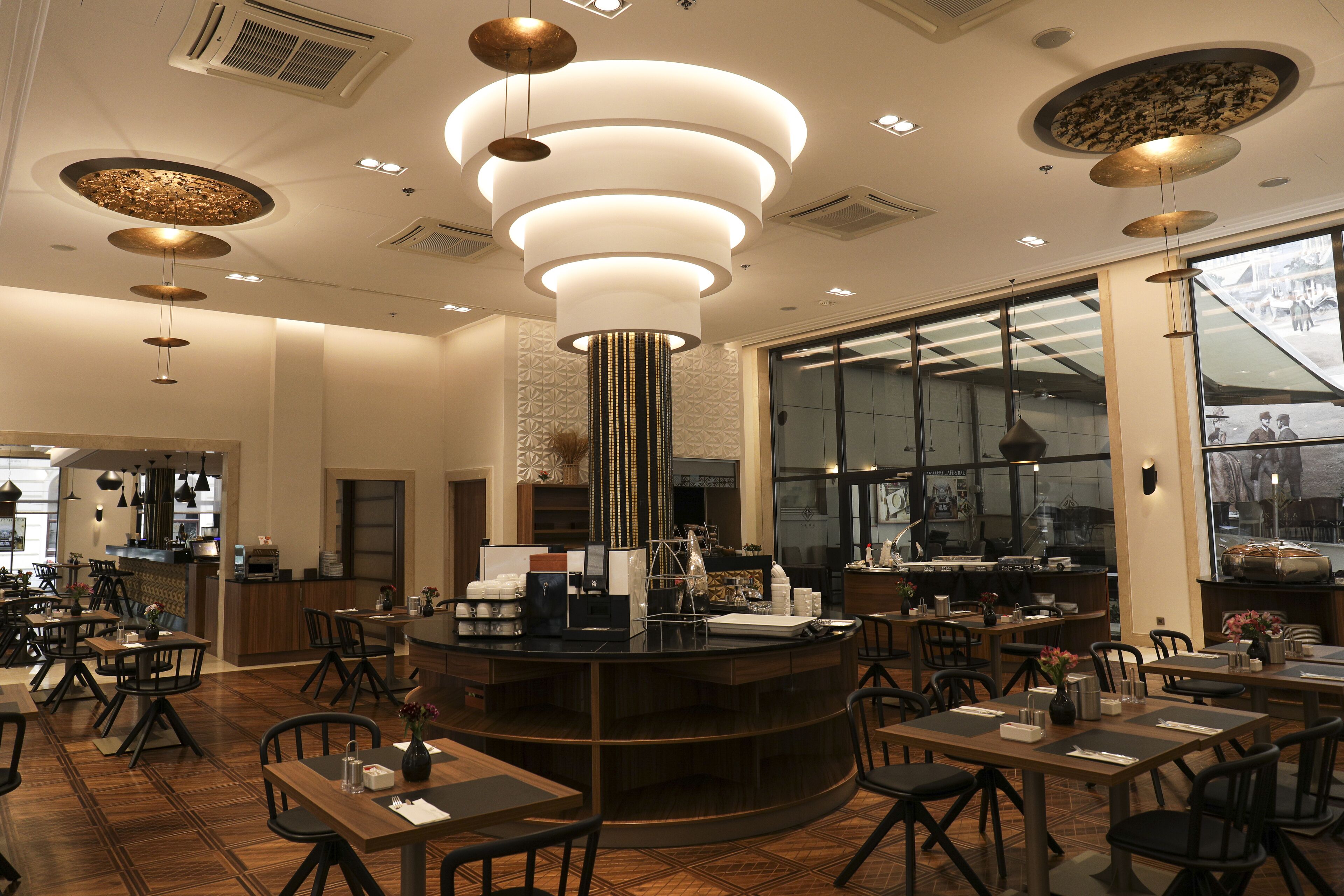 Un restaurante moderno con barra central, suelo de madera e iluminación colgante.