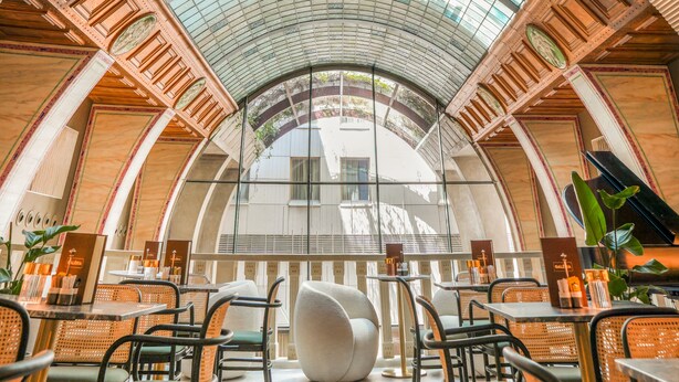 A spacious indoor area with a high, arched glass ceiling and a central seating area with modern chairs and tables. - Continental Hotel Budapest (Budapest)