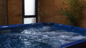 Un jacuzzi en una habitación con paredes de ladrillo y una ventana.