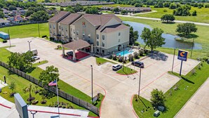 A hotel with a central courtyard, a swimming pool, and a parking lot. - Comfort Inn & Suites Navasota (Navasota)