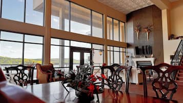 A spacious room with large windows, a fireplace, and a view of the outdoors.