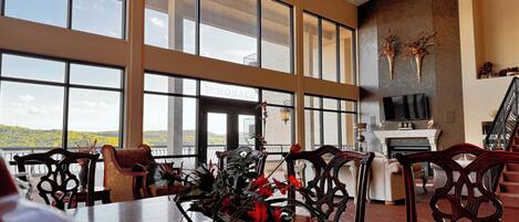 A spacious room with large windows, a fireplace, and a view of the outdoors.
