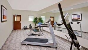 A fitness room with a treadmill, exercise bike, and a mirrored wall. - Microtel Inn & Suites by Wyndham Geneva (Geneva)