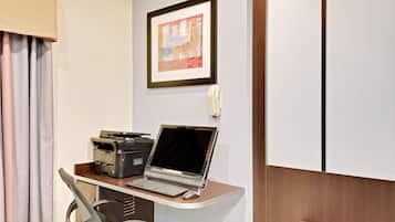 Une chambre d’hôtel équipée d’un bureau, d’un ordinateur portable, d’une imprimante et d’un téléphone.