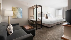 A hotel room with a sofa, a desk, a bed, a TV, and a large window. - SpringHill Suites by Marriott San Angelo (San Angelo)
