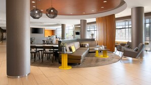 A spacious lobby with a curved ceiling, seating area, and a dining setup. - SpringHill Suites by Marriott San Angelo (San Angelo)
