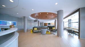 A spacious lobby with a reception desk, seating area, and large windows providing natural light. - SpringHill Suites by Marriott San Angelo (San Angelo)