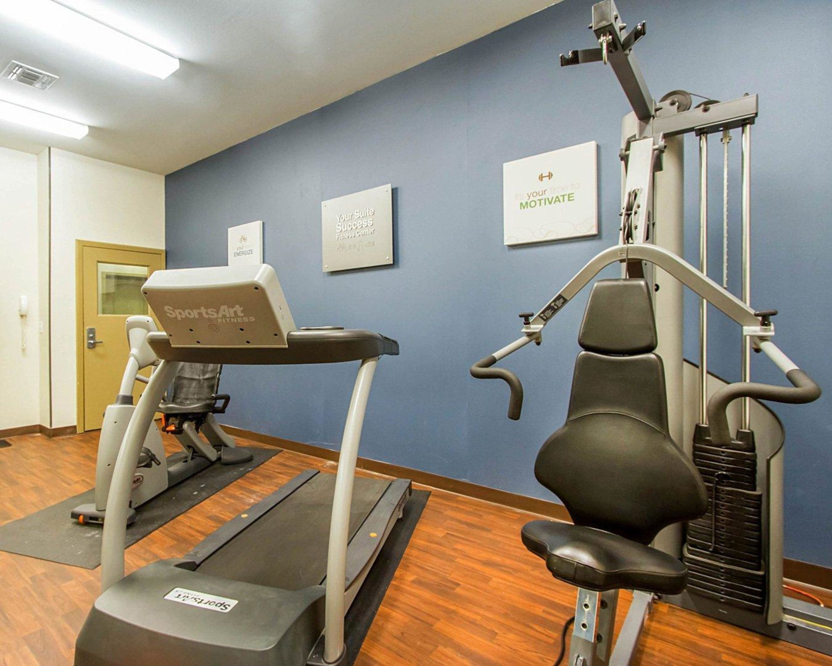 A fitness center with a treadmill, a stationary bike, and a weight machine.