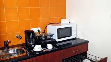 Refrigerador, microondas, cafetera y tetera y utensilios de cocina