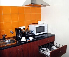 Refrigerador, microondas, cafetera y tetera y utensilios de cocina