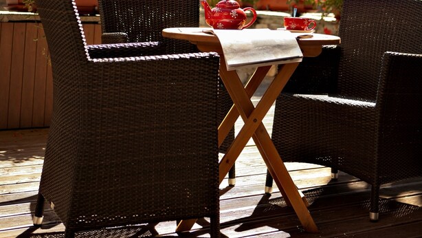 An outdoor seating area with wicker chairs and a table, overlooking a mountainous landscape. - CGH Résidences & SPAS Le Ruitor (Sainte-Foy-Tarentaise)