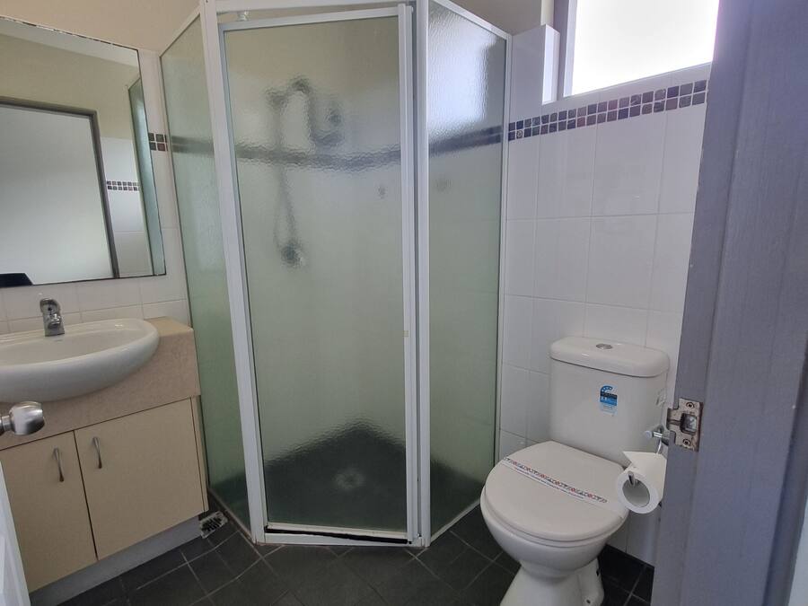 Un bagno con doccia vetrata, un water e un lavandino.