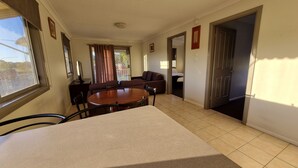 Une pièce spacieuse avec une grande table à manger, un ventilateur de plafond et une vue par la fenêtre.