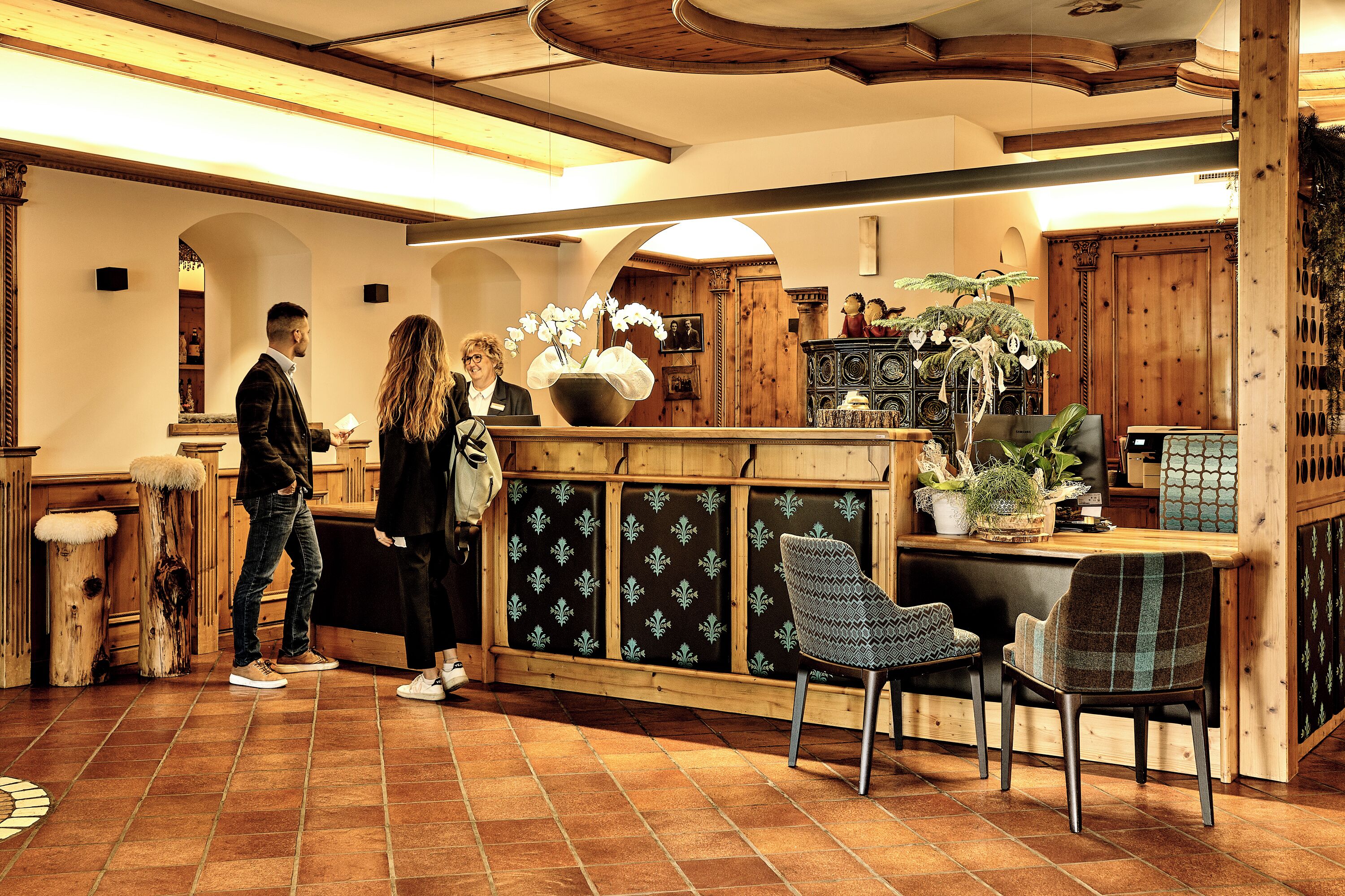 A restaurant with wooden furniture, a tiled floor, and a counter with a plant.