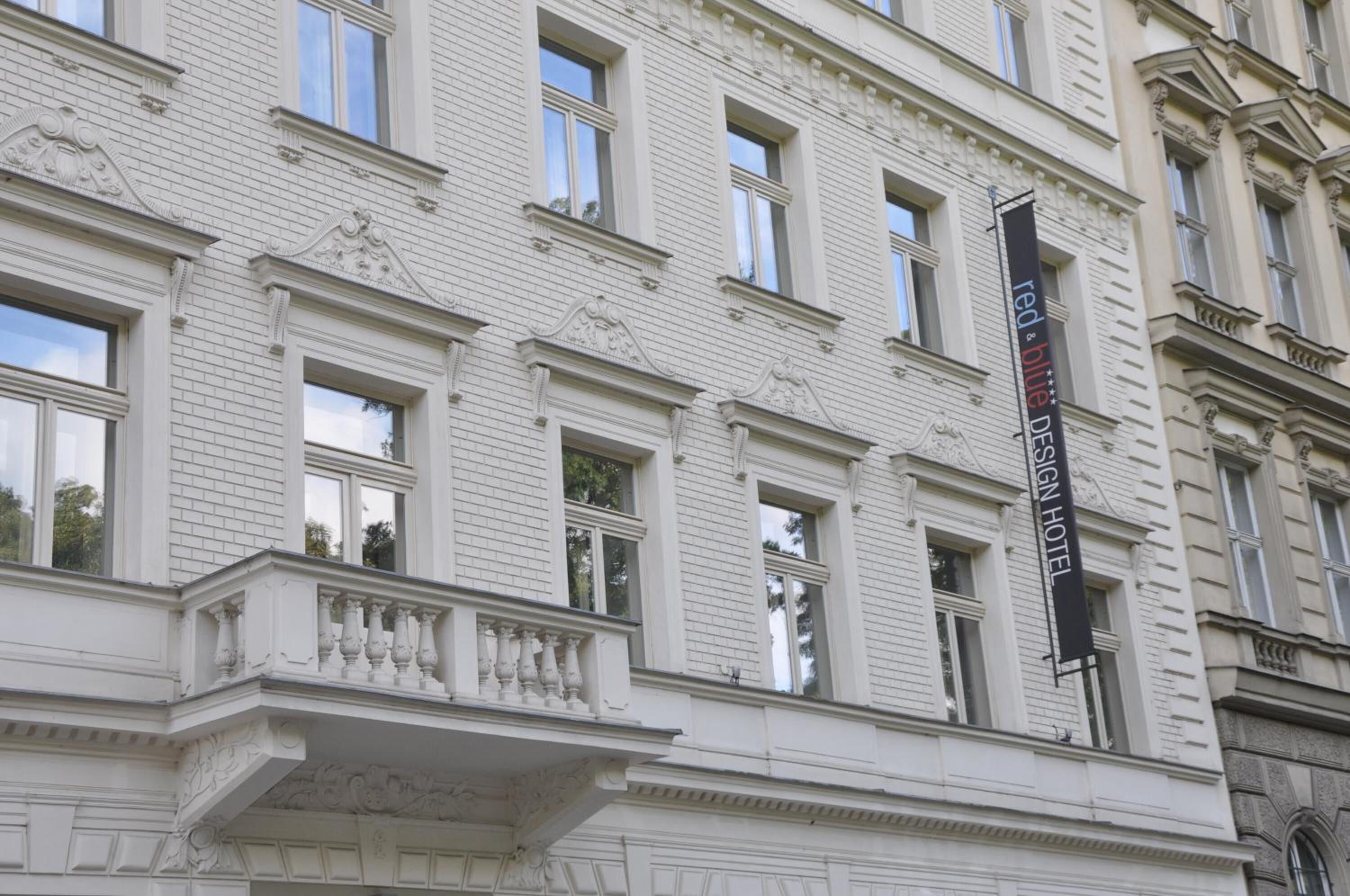 A historic building with a prominent black sign for the Red Blue Design Hotel.