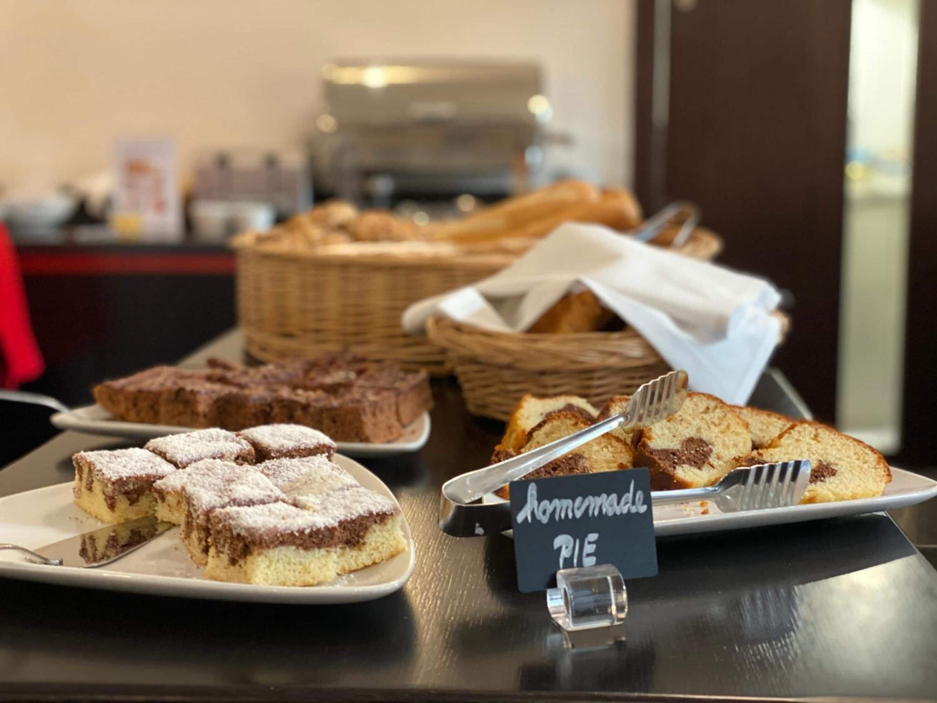 Un présentoir de desserts avec des tartes faites maison et d’autres pâtisseries.