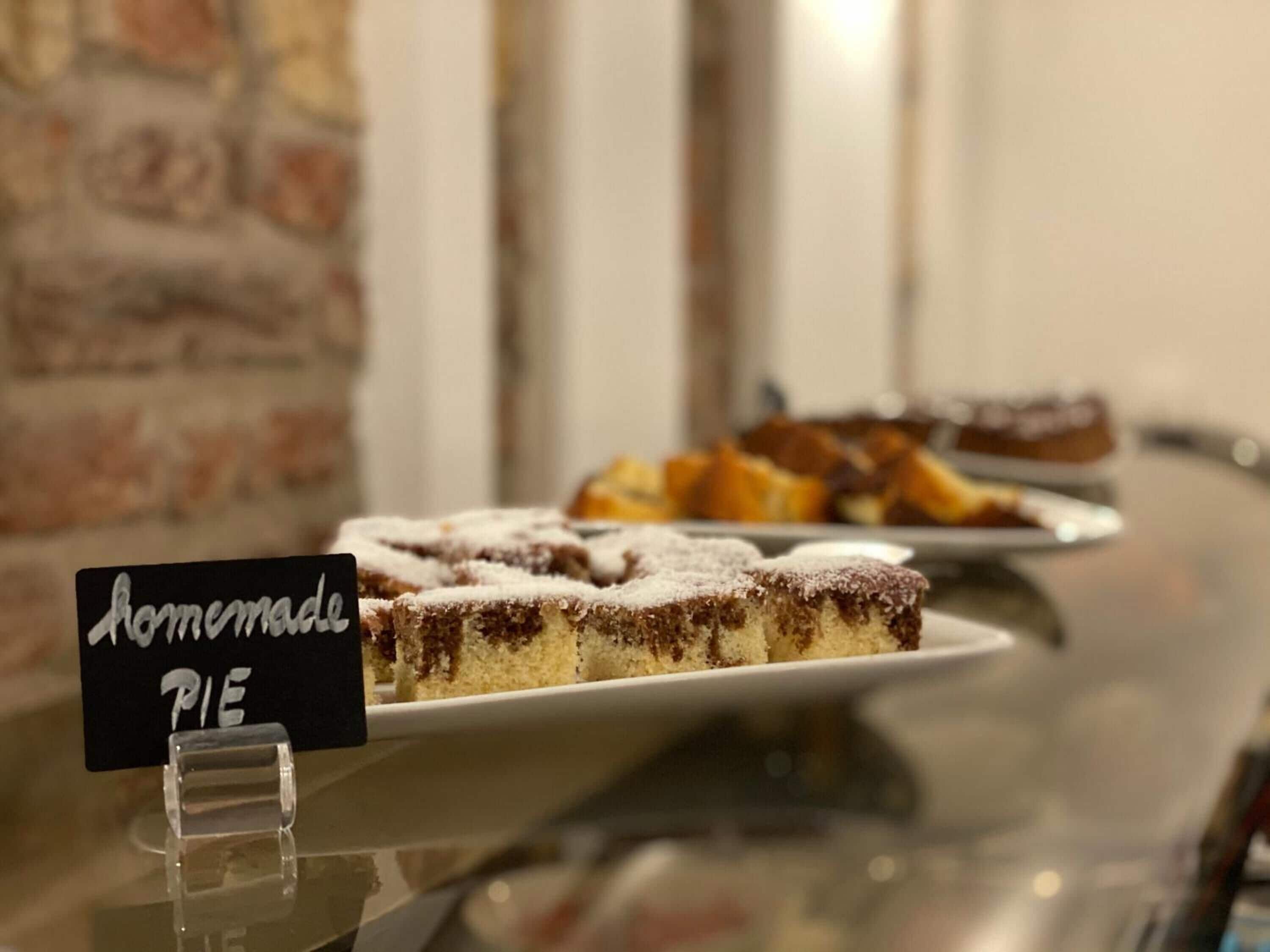 Un présentoir de desserts avec une pancarte indiquant que les tartes sont faites maison.