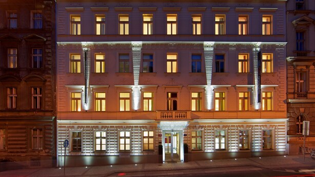 A multi-story hotel with a classic architectural design, featuring a central entrance with a glass door and a sign above it. - Red and Blue Design Hotel Prague (Prague)
