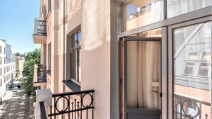 Un apartamento moderno con balcón, ventanas amplias y vistas a la calle.
