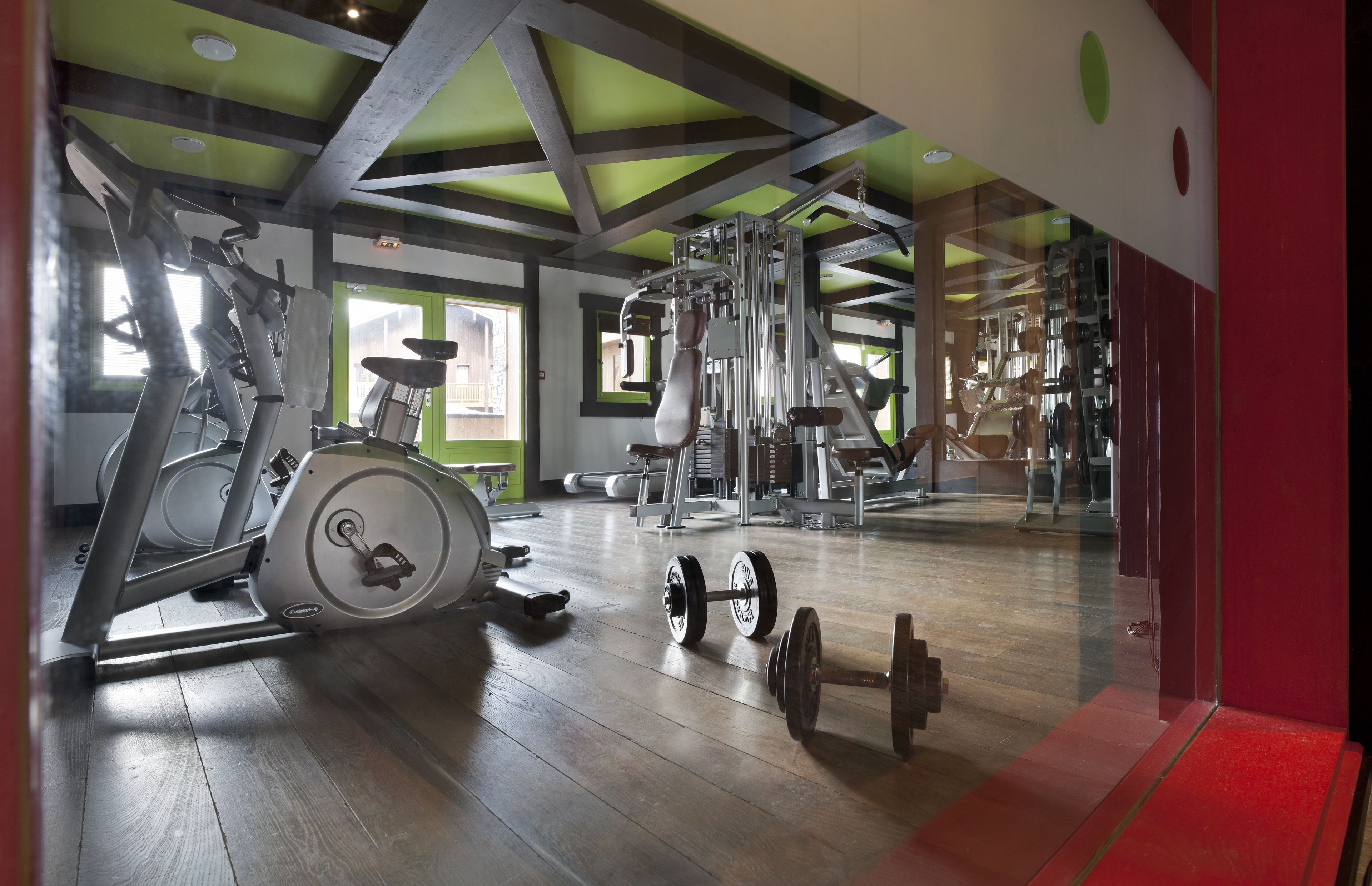 A gym with exercise equipment, including treadmills, a stationary bike, and free weights.
