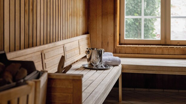 Un interior de madera con un banco, una ventana y una puerta.