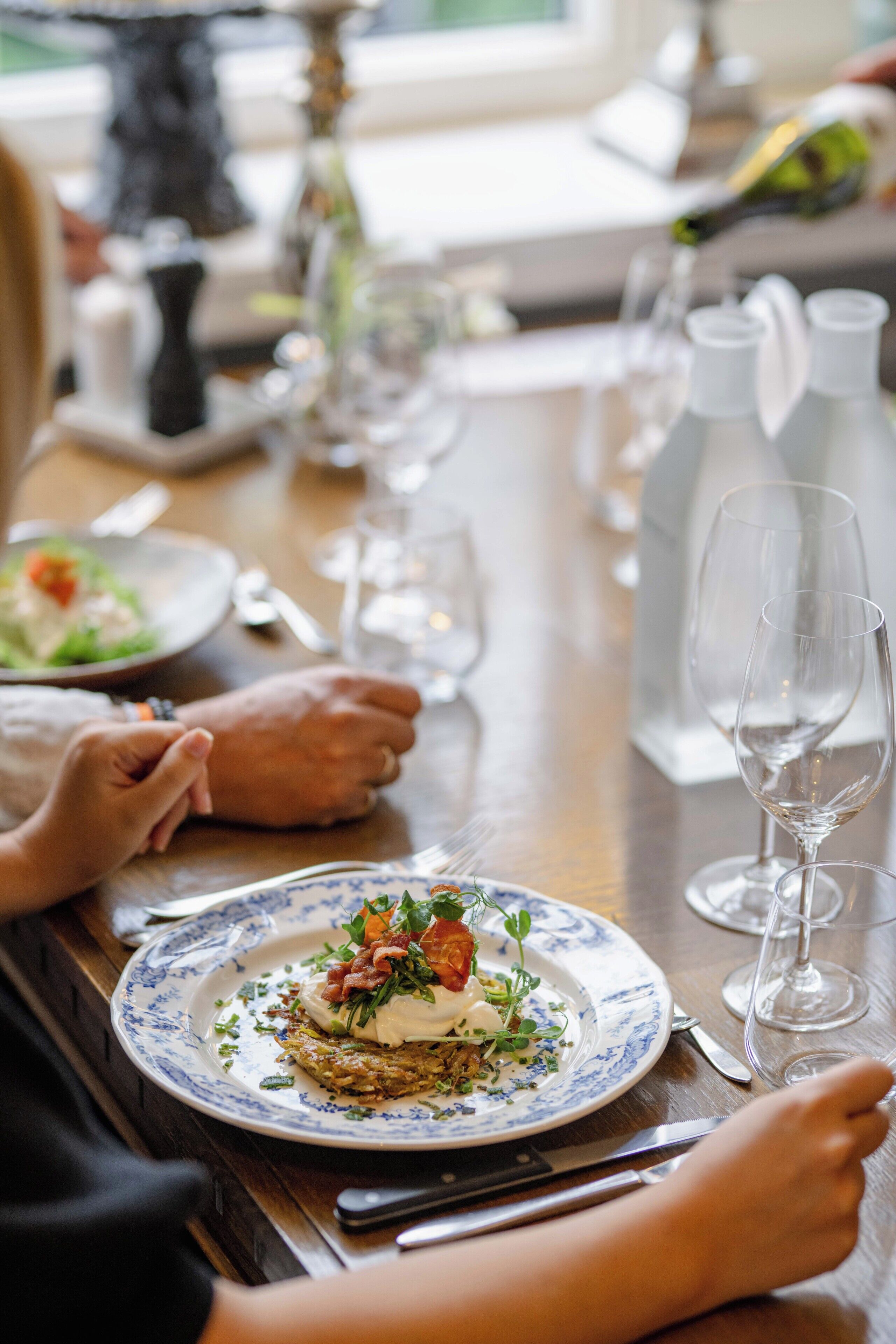 Une table à manger avec des assiettes, des couverts et des verres.