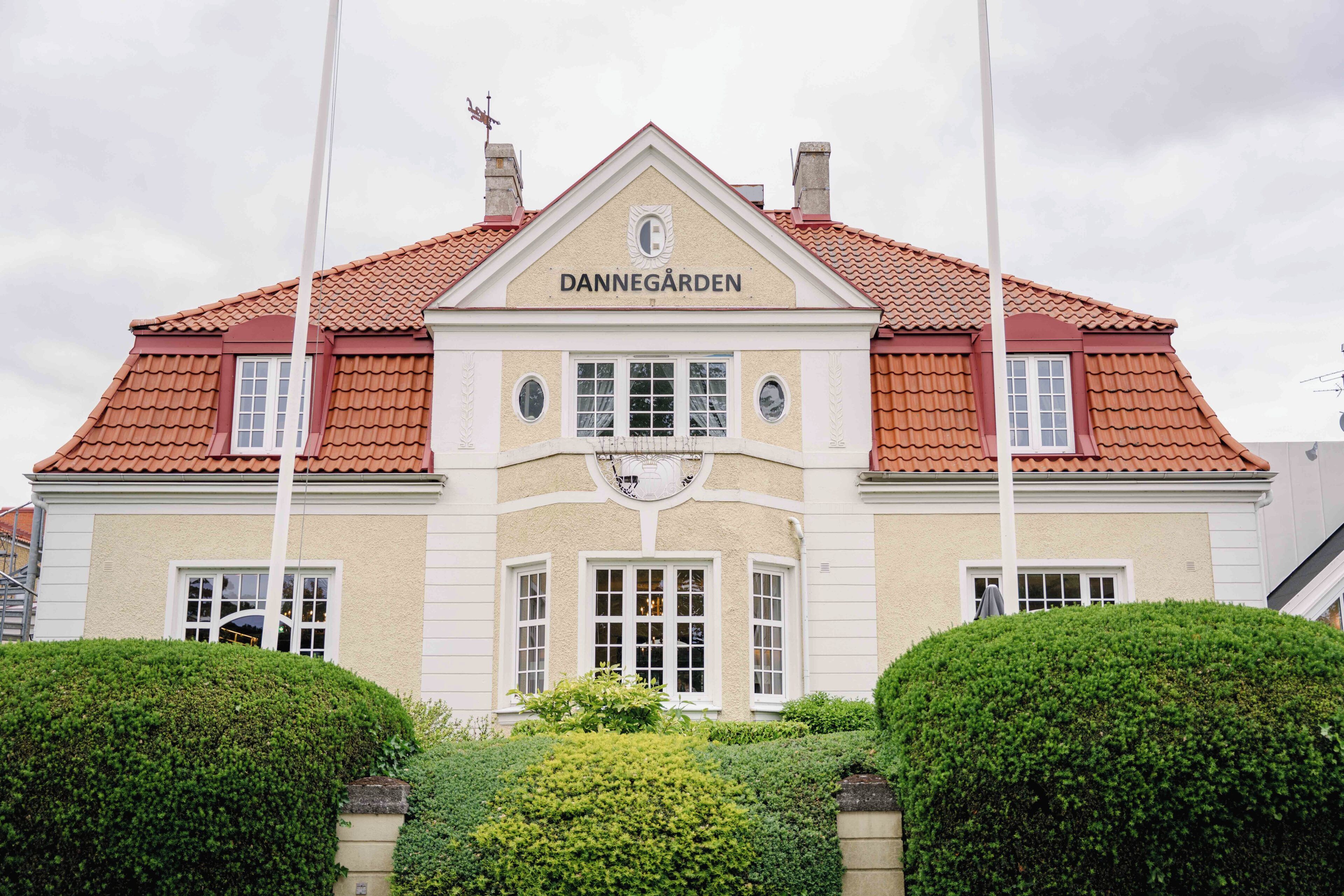 A building with a sign reading 'DANNEGAARDEN' and a red-tiled roof.