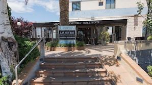 A hotel entrance with a staircase leading up to the door, a sign indicating the hotel name, and a view of the building's exterior. - Hotel Las Ventas (Utebo)