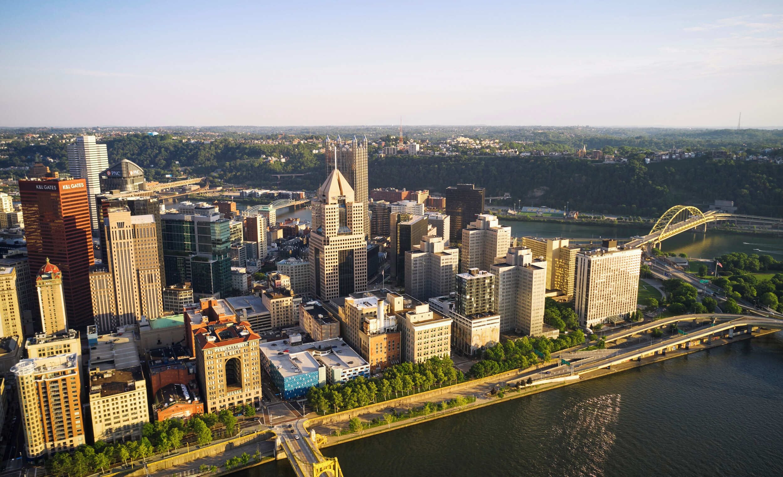 A cityscape with high-rise buildings, a river, and a bridge.
