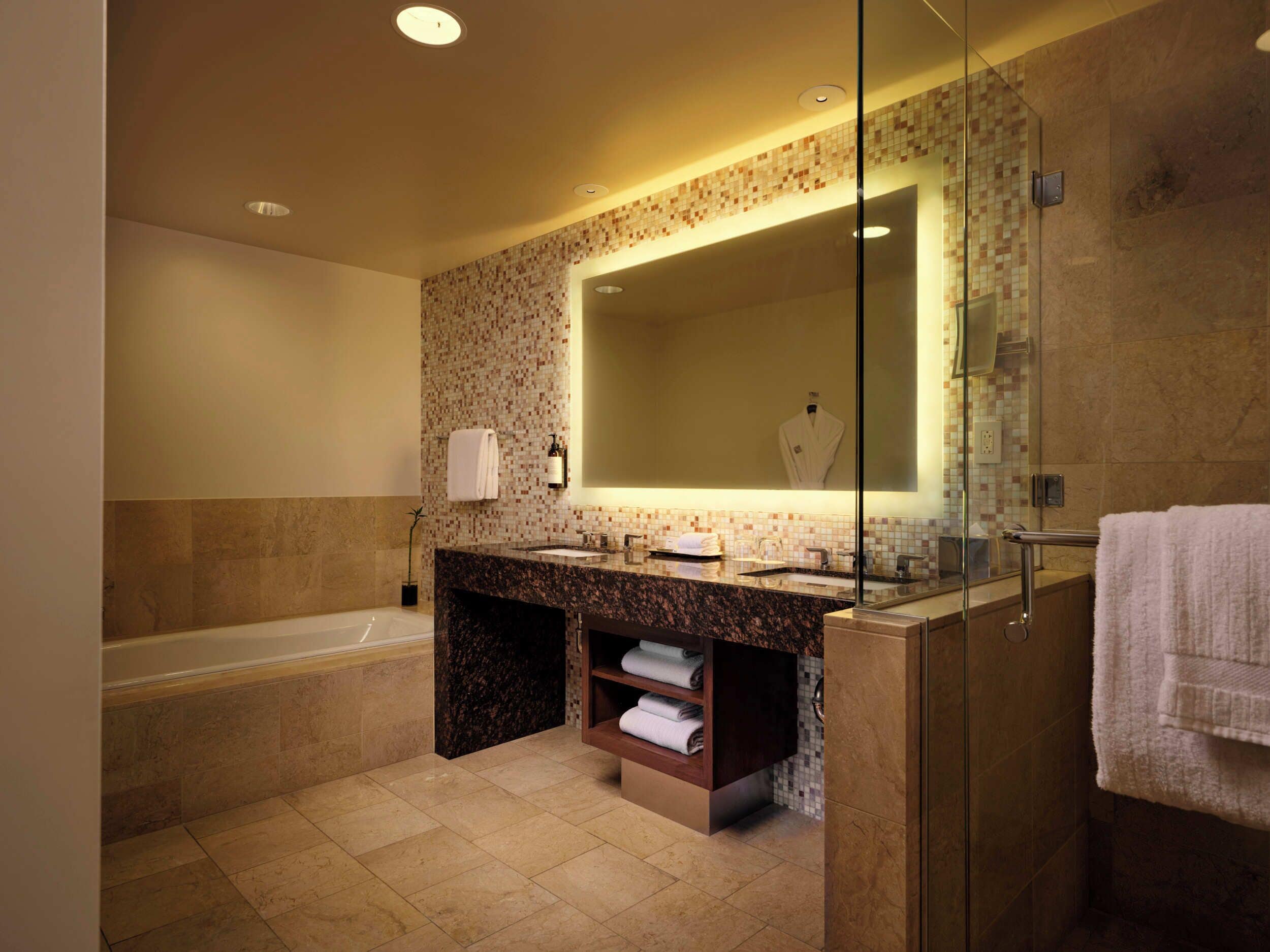 A modern bathroom with a glass-enclosed shower, a marble vanity, and a large mirror.