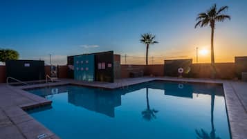 Relax by the serene pool, surrounded by a well-maintained patio with a clear view of the horizon.