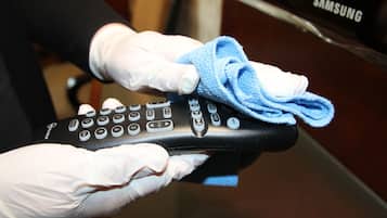 Une personne tenant une télécommande recouverte d’un tissu bleu.
