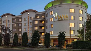 Un hôtel à plusieurs étages, doté d’une façade incurvée, de balcons et d’une enseigne bien visible indiquant « Viana Hotel & Spa ».