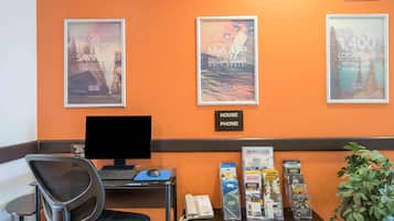 A reception desk with a computer, phone, and informational brochures.