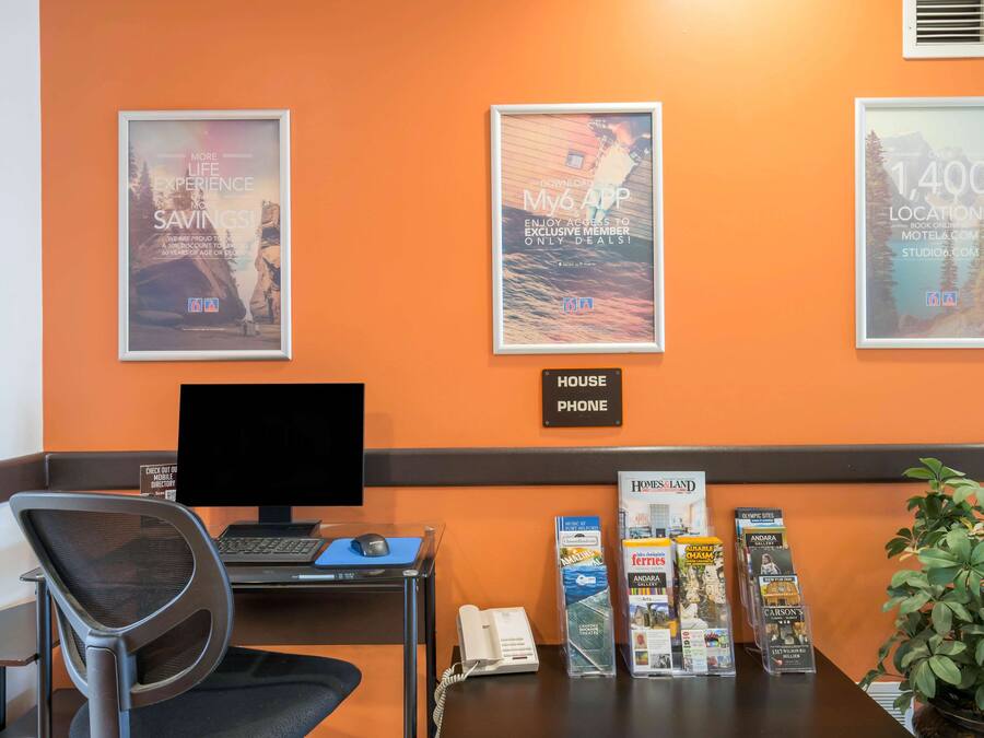 A reception desk with a computer, phone, and informational brochures.