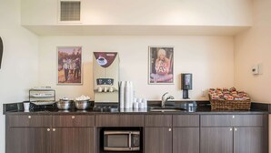 Una cocina moderna con microondas integrado, máquina de café y una cesta de aperitivos.