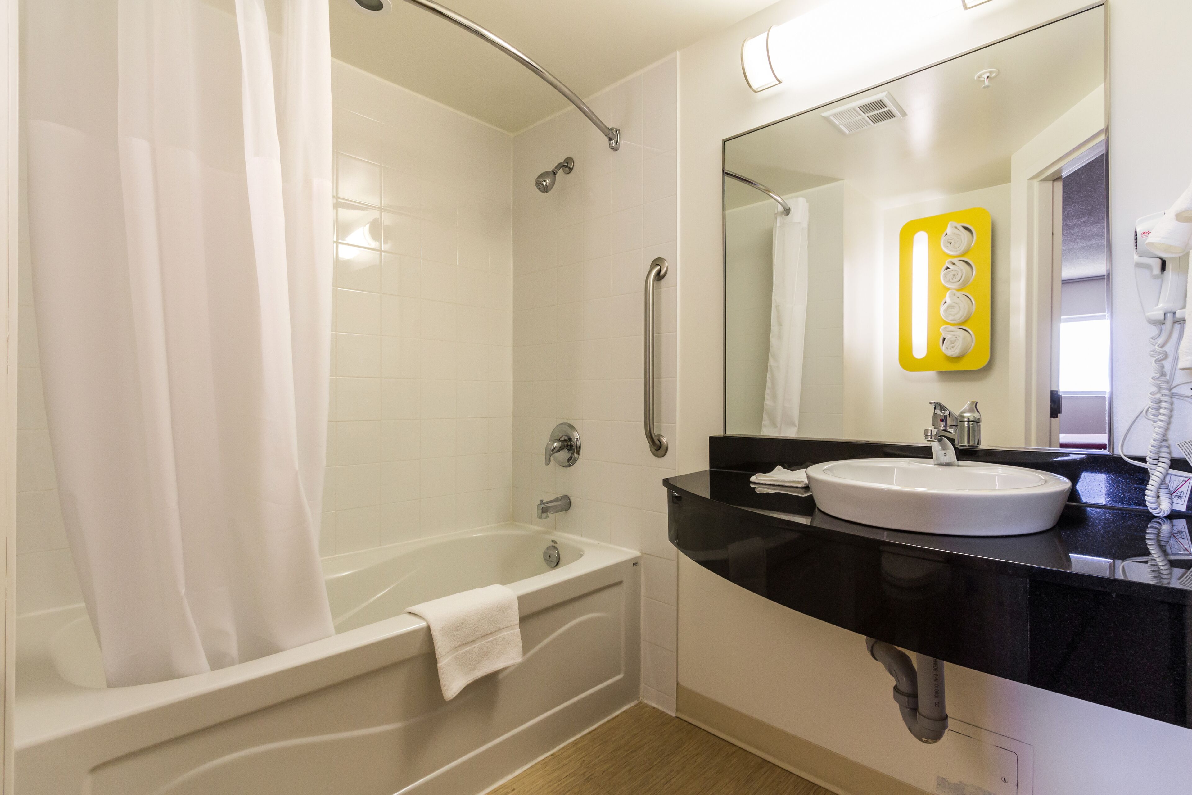 Un baño con bañera, lavamanos y espejo.