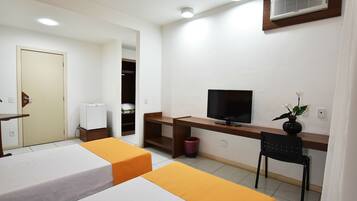 A hotel room with two beds, a desk with a TV, a chair, a small trash bin, and a wardrobe.