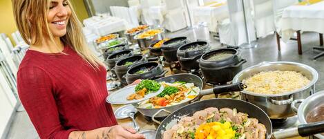 A buffet with various dishes, including meats, vegetables, and rice.