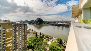 A high-rise building with a view of a river and mountains in the distance.