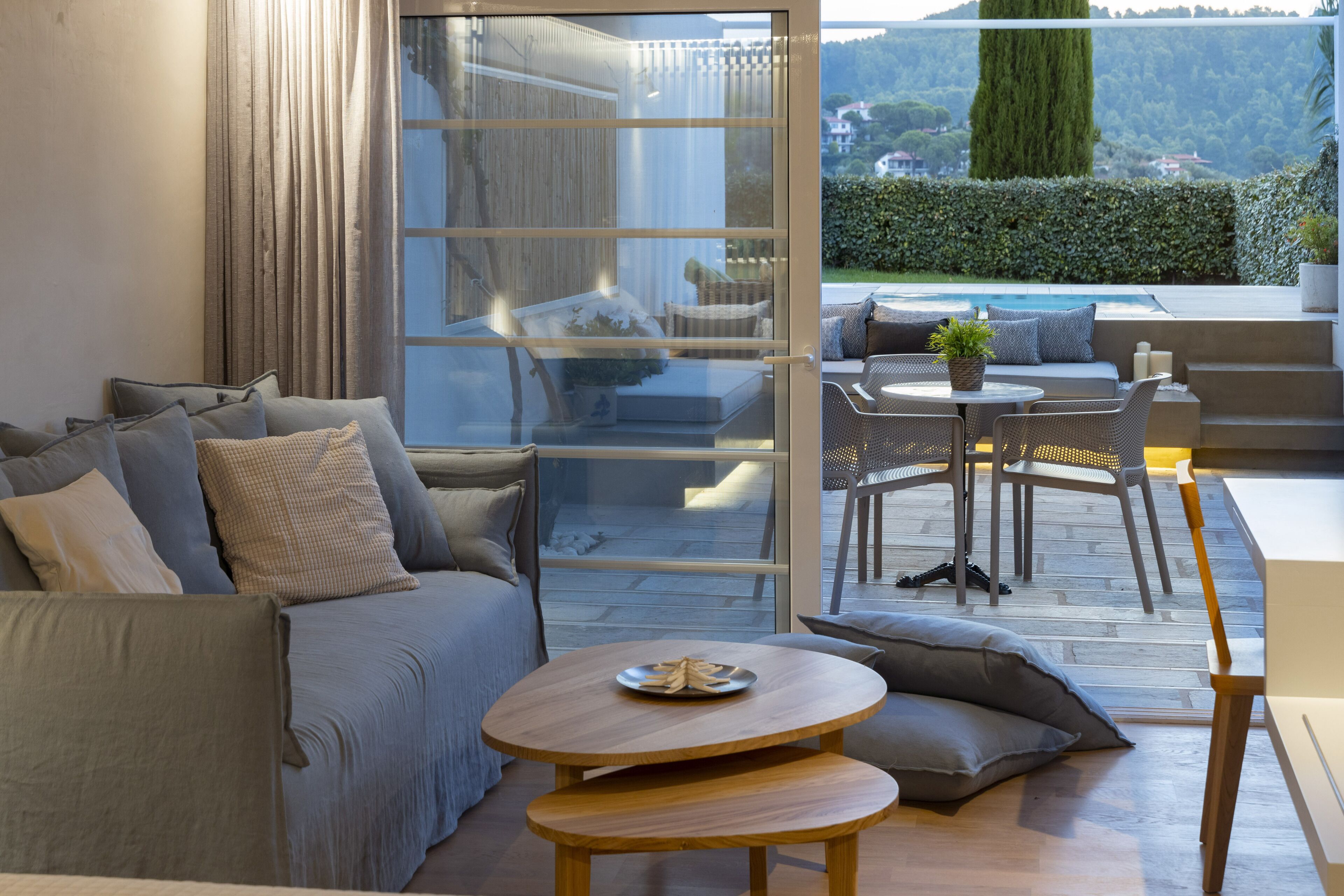 A modern living room with a sofa, a coffee table, and a dining area with chairs.