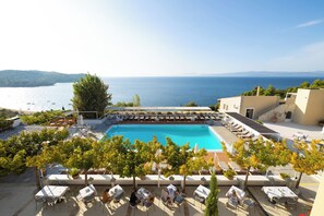 A rooftop pool with a view of the sea, surrounded by lounge chairs and tables. - Atrium Hotel (Skiathos)