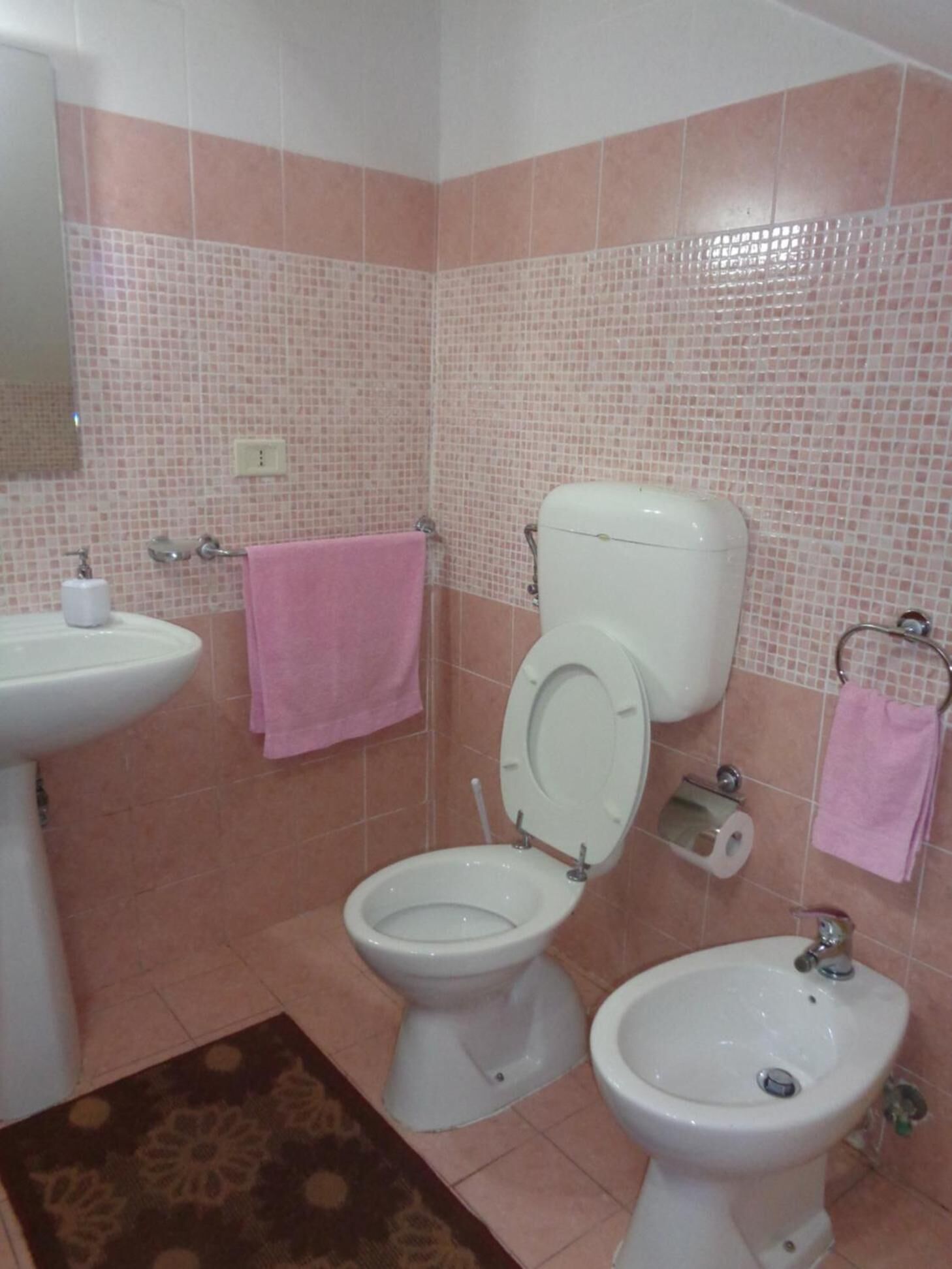 A bathroom with a toilet, bidet, and sink.